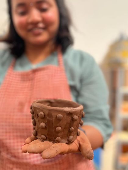 A participant from the Teach for India team building retreat proudly displays the textured pot she made. It is so rewarding to see the unique character each person brings to their creation.