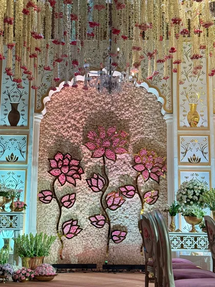A view of the mandap wall, where floral backdrops are accented with elegant chandeliers. This combination of soft blooms and sparkling light creates a truly magical atmosphere.
