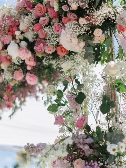 A close-up view of the intricate floral work on one of our engagement arches. We layer different varieties of roses, baby's breath, and eucalyptus to create rich texture and depth, showing our commitment to detailed craftsmanship.