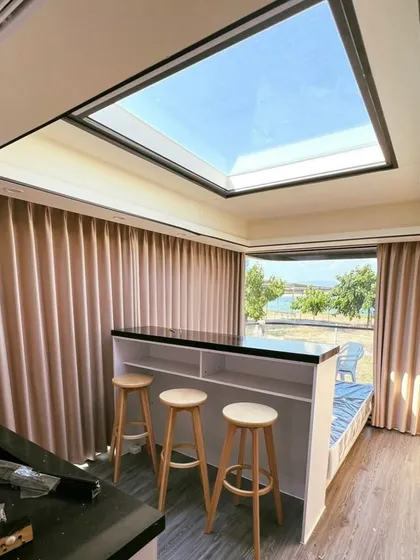 The bar and seating area inside the Space Capsule E8, positioned under a large skylight. It’s a perfect spot for enjoying a drink while taking in the sky view.