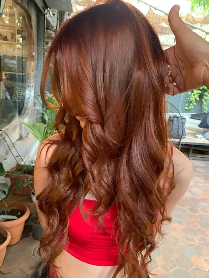 A side profile of the 'Cowboy Copper' look. The color is warm and flattering, and the waves add beautiful movement.