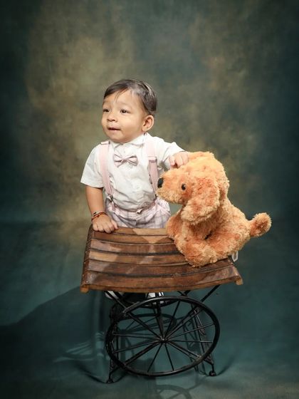 A boy and his furry friend. Using props like this little cart and teddy bear makes toddler photoshoots fun and helps bring out their playful side.