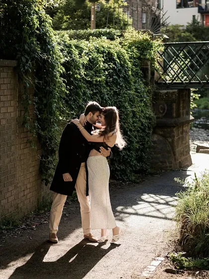 An intimate embrace in a sun-dappled, ivy-covered corner of Edinburgh. This shot feels private and deeply romantic, capturing a quiet moment of connection.