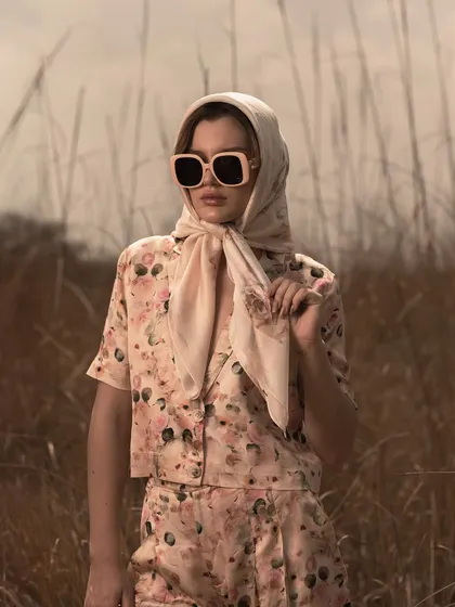 A variation of the headscarf look, this pose feels more classic and poised. It shows the versatility of a single outfit through different styling and model direction.