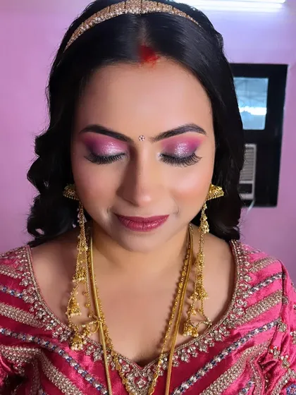 A close-up of the reception eye makeup for Pooja. The shimmering pink and purple tones create a glamorous and eye-catching look perfect for an evening celebration.