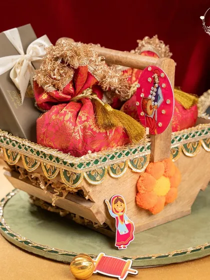 This unique Lohri hamper comes in a foldable wooden basket, filled with brocade potlis and a box of sweets. It's a beautiful and practical gift that can be cherished for years.