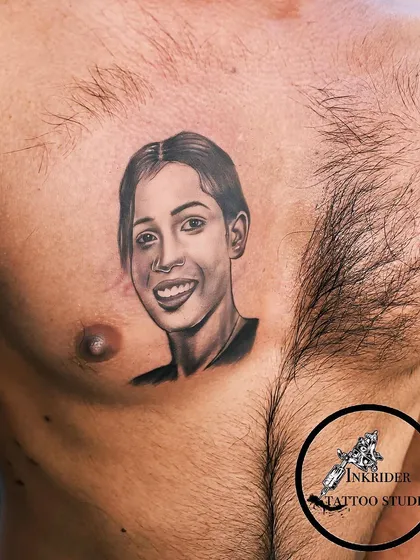 Another example of our portrait work, this piece captures a smiling face with soft shading and detail. These tattoos are a beautiful way to keep a loved one close.