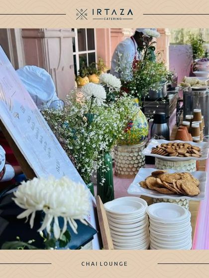 A lovely outdoor "Chai Lounge" setup for a wedding event. Complete with traditional tea, biscuits, and beautiful floral decor, it provides a charming and relaxed space for guests.