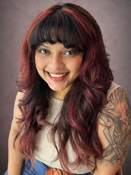 Your haircut should match your personality. For this client, I created an edgy rock chick shag with bold red accents to complement her style.