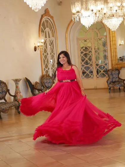 A "twirling" shot to show the beautiful movement of this flowy pink pre-wedding gown. It's perfect for capturing dynamic and joyful moments in a grand ballroom.