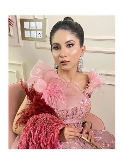 Rent or buy this beautiful pink gown with feather and organza flower details on the shoulder.