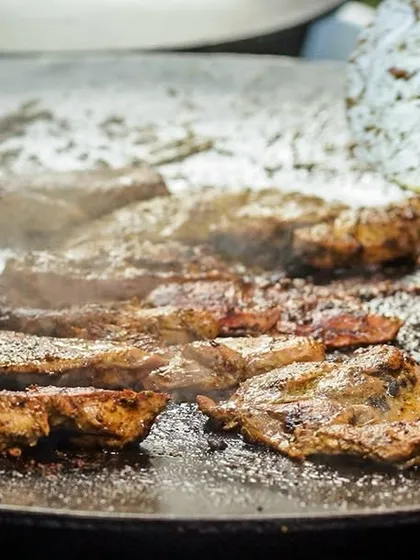 Sizzling meat on a hot tawa, a key part of our live cooking experience that fills the air with an irresistible aroma.