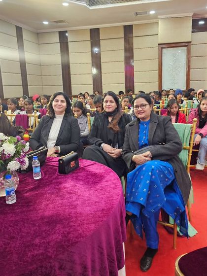 Seated in the audience at the summit, listening to inspiring speakers.