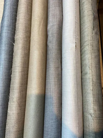 A selection of woolen-blend fabrics in various neutral shades. These are ideal for creating custom trousers or light jackets with a textured, high-end feel.