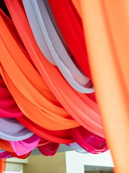An abstract, close-up shot of the colorful draped ceiling, highlighting the flow and translucency of the fabrics.