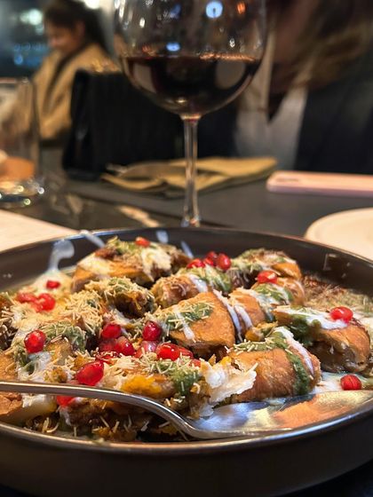 A glass of red wine paired with chaat. This shows how I create content around the full dining experience, including drink pairings.