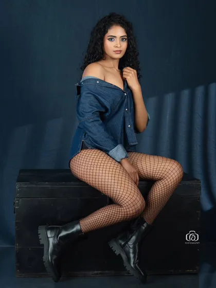 A studio glamour shot combining denim, fishnet stockings, and combat boots for an edgy look. I used a gobo to cast a subtle shadow pattern, adding texture and mood to the portrait.