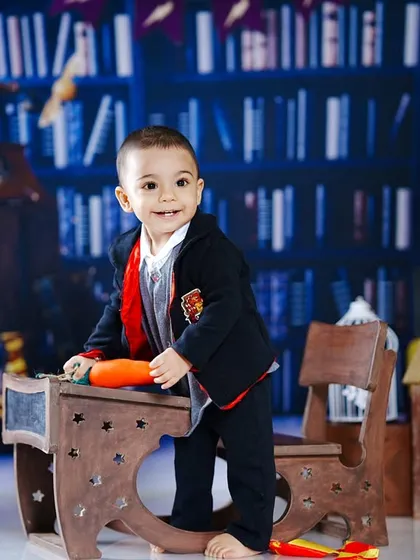 An action shot of the young wizard standing by his desk, ready to practice some spells.