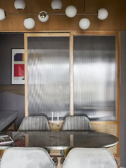 Good design is also clever design. This fluted glass and wood screen looks like a decorative feature, but it slides away to reveal a compact and fully functional home office, tailored to the client's needs.