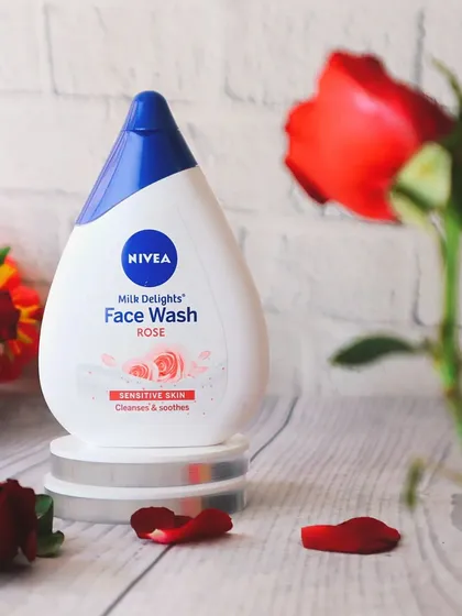 A second angle of the Nivea rose face wash, with a single red rose in the foreground to draw the eye and reinforce the floral ingredient.