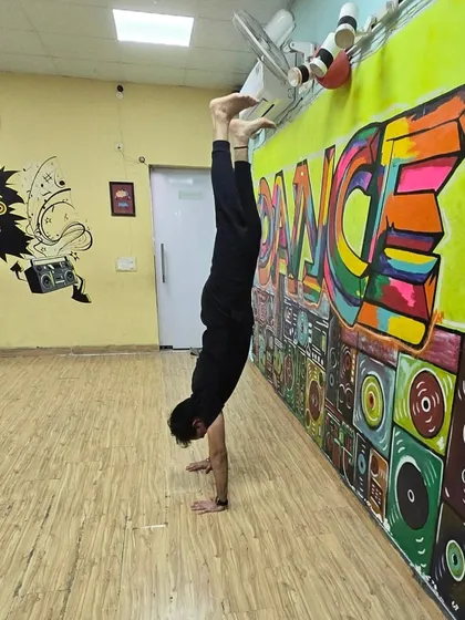 Consistency is everything. Here I am practicing a handstand in my studio, a pose that requires strength, balance, and dedication, which are the core principles I teach.