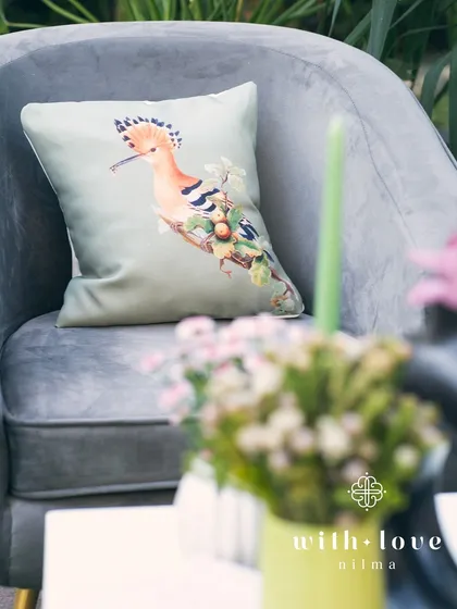 It's all in the details. A custom-printed cushion with a hoopoe bird design adds a personal and whimsical touch to the baby shower decor.