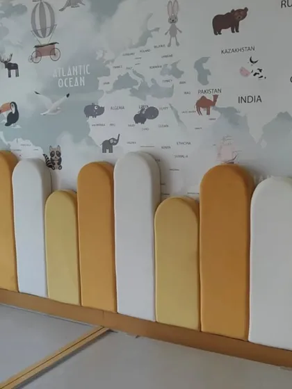 We can bring any theme to life, like this world map wallpaper for a child's room. Paired with a custom-cushioned headboard, it creates a fun and educational space. This is a great example of an accent wall that transforms a room's entire feel.