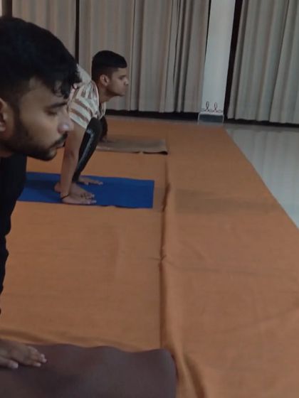 Participants in a forward bend, a posture that brings flexibility to the spine and calmness to the mind.