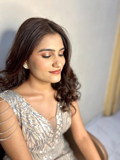 A side profile showing the beautiful soft curls and the subtle contouring that enhances her features. This look is all about understated elegance.