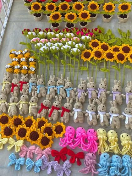 A large group of amigurumi bunnies with colorful scarves, ready for a wholesale client.