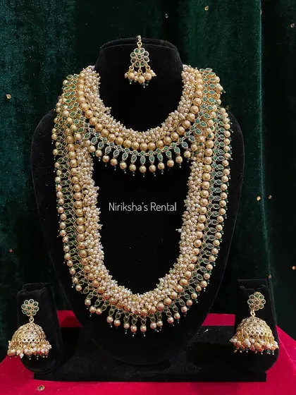 For a softer look, I offer this beautiful multi-layered pearl necklace set with green bead accents and matching jhumkas.
