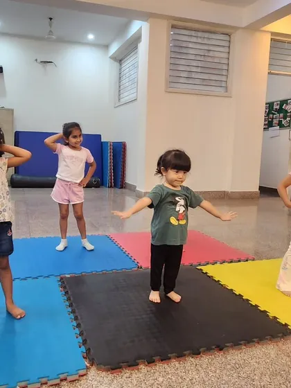 Our tiny dancers, aged 2-4, learning a new pose. We create a playful environment with colorful mats where they can learn basic dance postures safely.