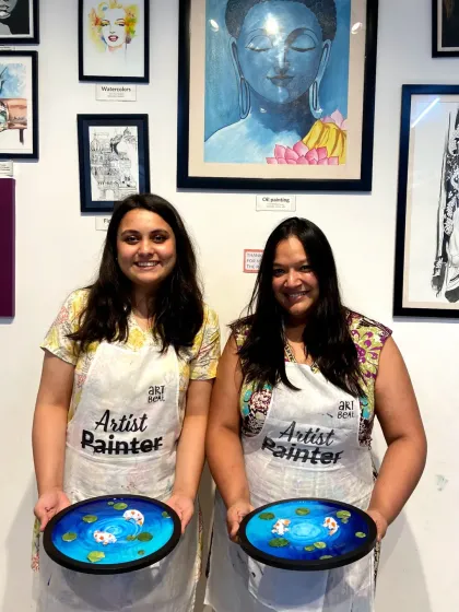 Two friends showing off the matching resin koi pond art they made. It's a wonderful way to spend time together and leave with a beautiful, coordinated set of artworks.