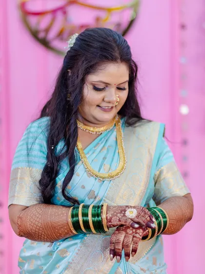 A sweet, candid moment as the bride-to-be admires her intricate mehndi design. The makeup is designed to last, looking fresh and perfect through every part of the celebration.