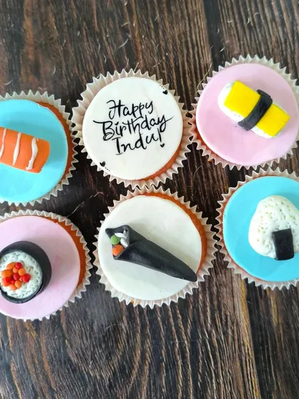 For the sushi lover, this set features a variety of hand-sculpted fondant sushi pieces, including nigiri, maki, and temaki rolls, all sitting on colorful, edible discs.