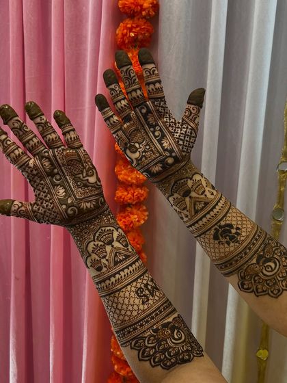 A full view of the intricate bridal mehendi, with a festive background of marigold flowers.