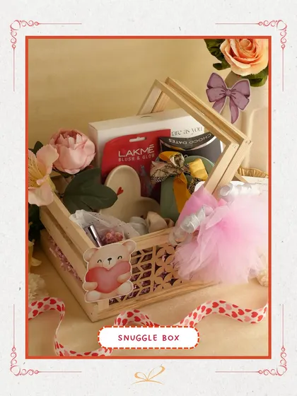 The 'Snuggle Box' is a cozy and cute option. This wooden crate hamper is filled with skincare items like a Lakme face mask and other pampering products, perfect for a relaxing day in.