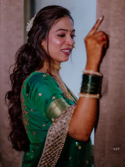 A candid shot of the bride enjoying her engagement party. The hairstyle is a modern take on a traditional look, with soft waves and a small hair accessory.