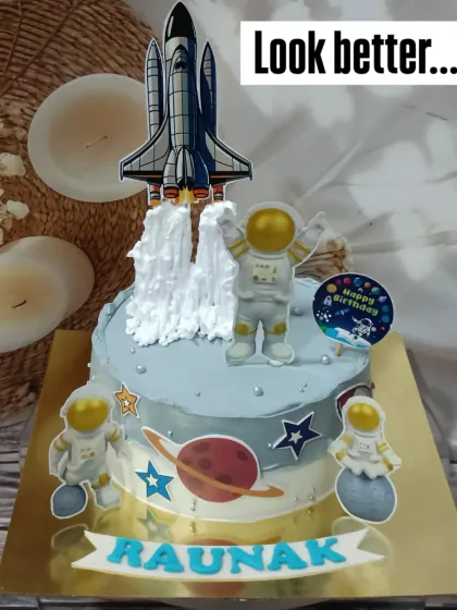 A cake for an aspiring astronaut. This space-themed design features a rocket ship, planets, and astronauts, perfect for a journey to the stars.
