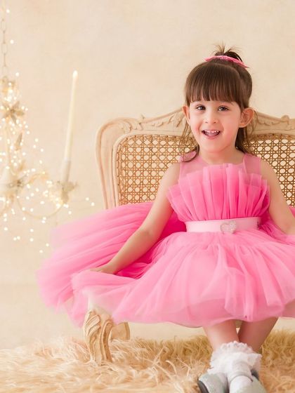 A pretty-in-pink portrait of a little girl in a beautiful tulle dress. Her happy smile makes this a truly delightful image.