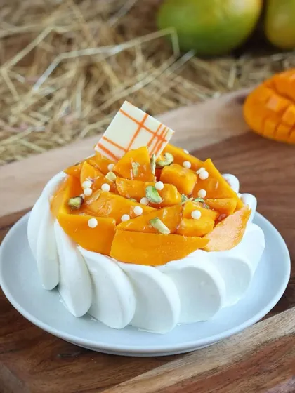 Our mini mango cake is a perfect single-serving treat, topped with fresh mango slices and pistachio slivers.