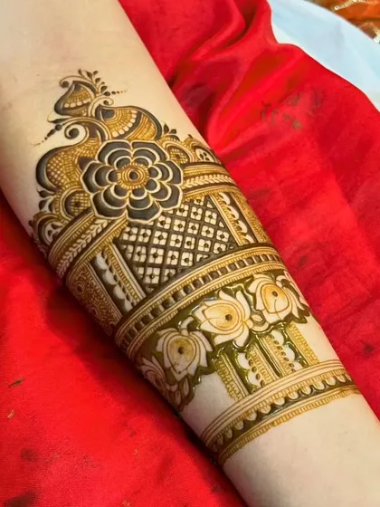 A close-up of the fusion arm piece, highlighting the central floral element and the peacock-inspired top.