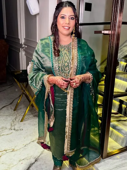 The full look, showcasing the elegant green outfit and the soft, glowing makeup.