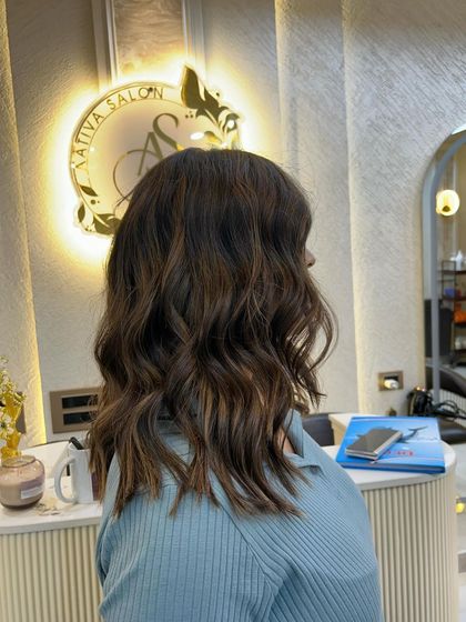 A beautiful caramel blond colour on medium-length hair. The warm tones and soft waves create a chic and stylish look.