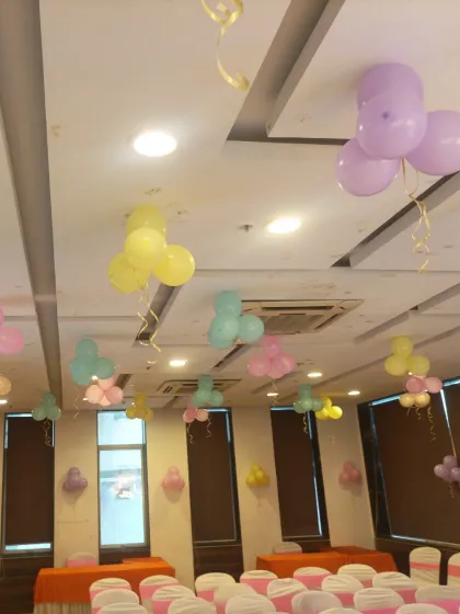 Simple ceiling decorations with pastel balloon bunches. This is an easy way to fill a large room and continue the party theme throughout the space.