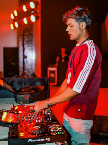 A close-up of me working the decks, with the warm stage lights creating a great mood.