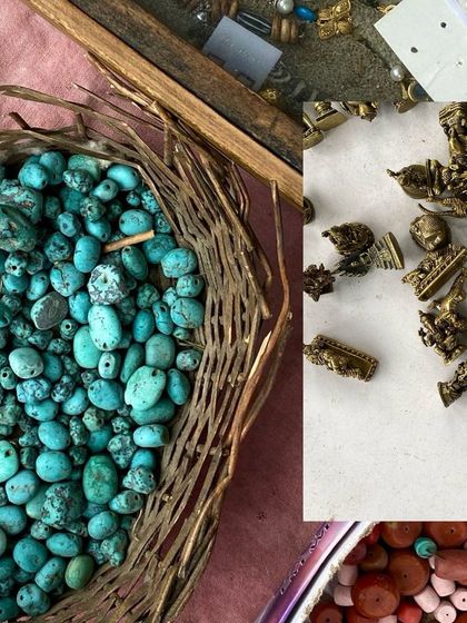 A basket of turquoise beads and small brass figurines from an antique stall.