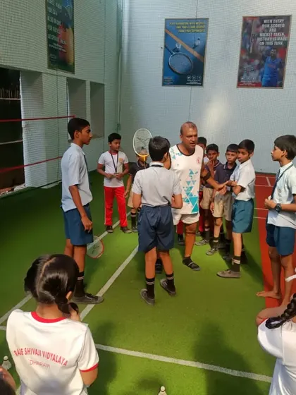 It's all about teamwork and listening. Our coach guiding the kids through the next set of badminton drills.