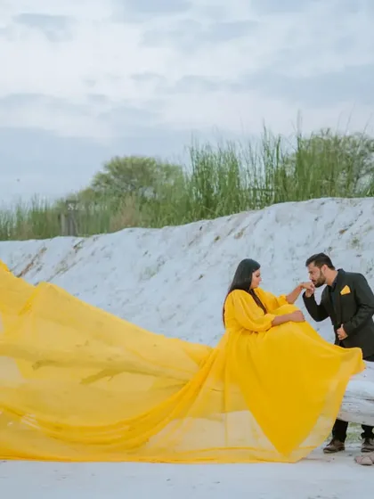 A tender, chivalrous moment amidst a surreal landscape. The flowing gown adds a touch of fairytale magic to this romantic pre-wedding photograph.