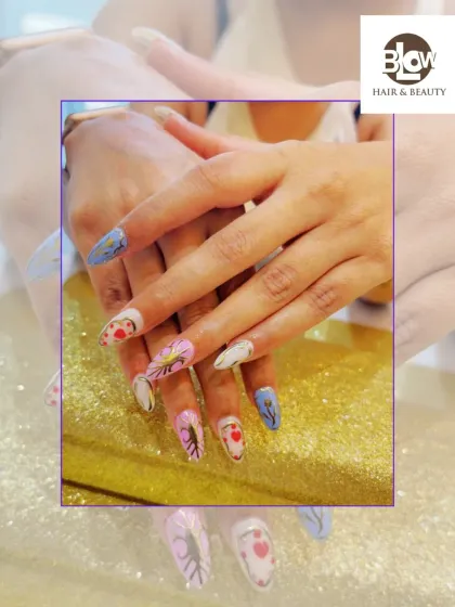 A showcase of detailed, hand-painted nail art. Each nail tells a different story with a mix of colors, delicate leaf patterns, and heart motifs, all done on long, stiletto-shaped extensions.